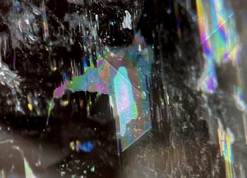 Irridescent-thin-film-features-in-a-spodumene