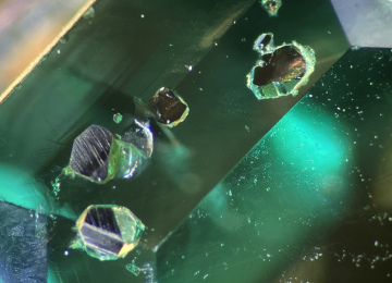 Surface-reaching-pyrite-crystals-in-a-Colombian-emerald
